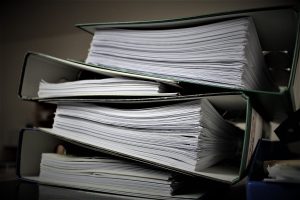 Comment les entreprises énergétiques modernisent leur gestion documentaire Close-up of stacked binders filled with documents for office or educational use.
